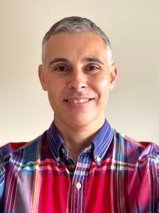 A head shot of Simon. He has short grey hair and is smiling. He is wearing a red and blue checkered shirt. A head shot of Simon. He has short grey hair and is smiling. He is wearing a red and blue checkered shirt.